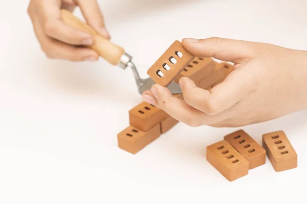 Κατασκευή μικρών μπλοκ τούβλων, παιχνίδι για την ανάπτυξη του παιδιού σε λευκό φόντο. — Φωτογραφία Αρχείου