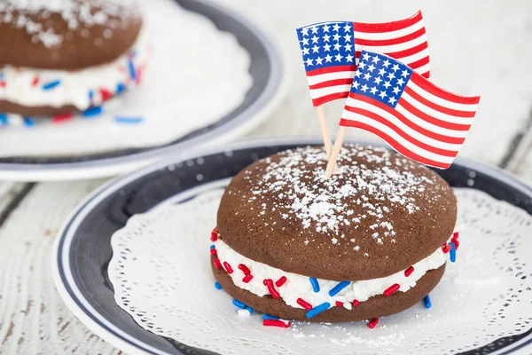 Whoopie 馅饼或月饼 巧克力蛋糕甜点充满奶油糖霜 装饰与美国国旗和红色 蓝色的 Sprinkels 庆祝7月4日 — 图库照片