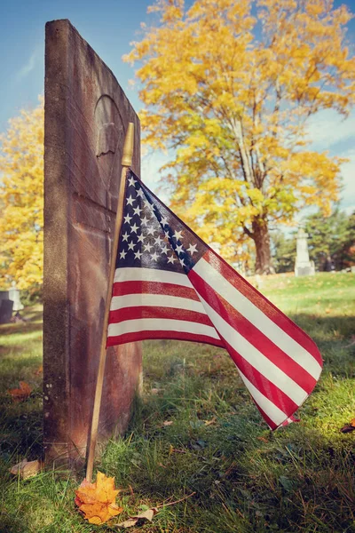 American veteran flag in autumn cemetery