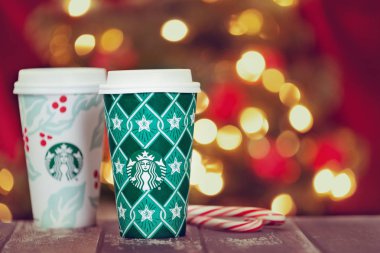 Dallas, Tx - 5 Kasım 2018: yeni tasarlanmış 2018 tatil bardak hizmet Starbucks popüler tatil yiyecek, içecek. Baston şekerler ile rustik tabloda görüntülenen. Neşeli Noel ışıkları arka plan.