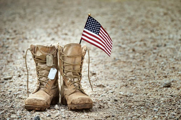 Velhas botas de combate militares com dog tags e uma pequena fla americana — Fotografia de Stock