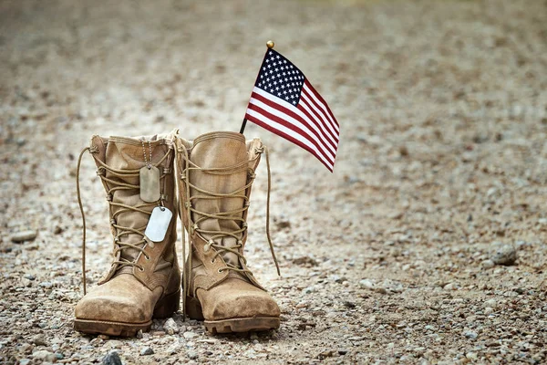 Alte Militärkampfstiefel mit Hundeanhänger und einer kleinen amerikanischen Fahne — Stockfoto