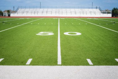Boş Amerikan futbol sahası stadyumunda 50 yarda çizgisi