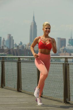 Güzel sarışın spor giyim bir sıcak yaz gününde koşu olarak yerleştirmek.