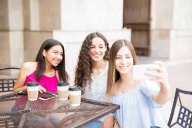 Kafe ve alma selfie cep telefonu ile dışarı asılı çekici genç kızlar.