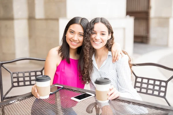 两个年轻女孩坐在一起在咖啡馆喝咖啡的肖像 — 图库照片