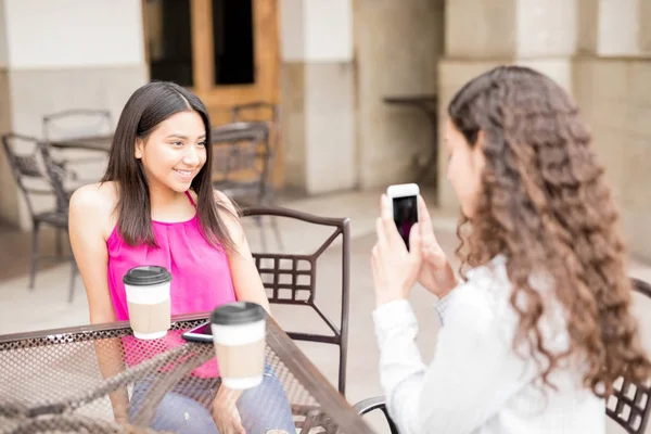 スマート フォンで写真のカフェで座っているかわいい若い女の子 — ストック写真