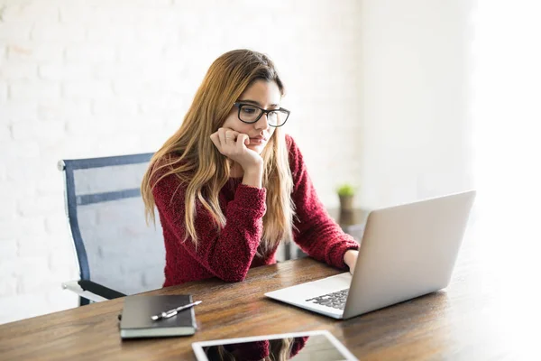 Nette Junge Frau Schaut Auf Ihren Laptop Und Denkt Nach — Stockfoto