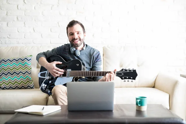 Retrato Joven Feliz Con Guitarra Sentado Sofá Con Ordenador Portátil —  Fotos de Stock