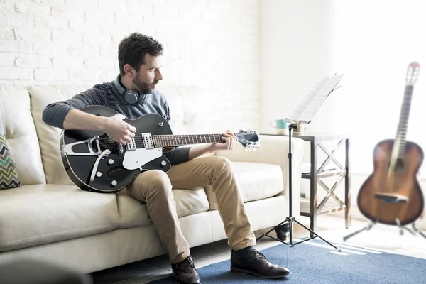 Schöner Lateinischer Mann Sitzt Auf Sofa Und Spielt Gitarre — Stockfoto