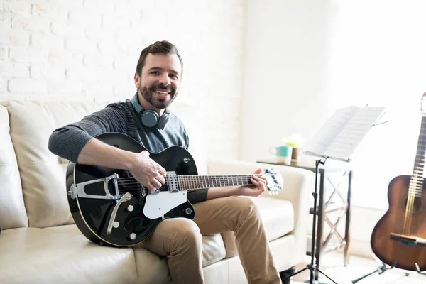Retrato Joven Sonriente Sentado Sofá Tocando Música Con Guitarra —  Fotos de Stock