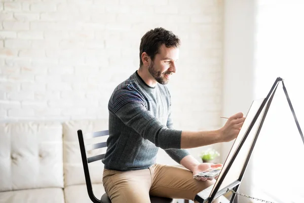 Happy Young Man Sitting His Living Room Doing Some Painting — Stock Photo, Image