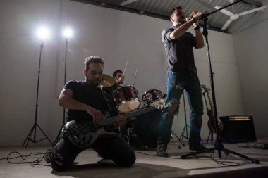 Onun kalbini dışarı şarkıcı ve baterist ile sahnede arkada oynayan gitarist kurşun