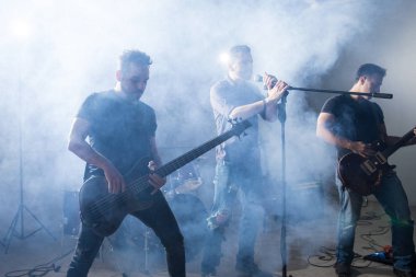 İki gitarist müzik konserinde sahne paylaşımı erkek rock şarkıcısı