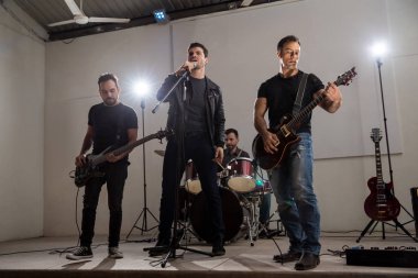 Gitarist ve davulcu müzik konserinde sahnede performans ile şarkıcı