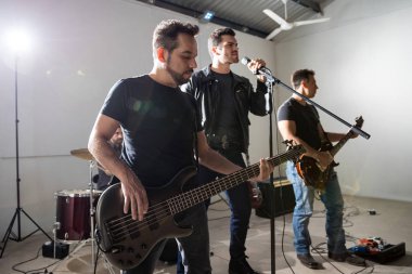 Canlı konser sahne alanı'nda rock grubunun performans, vokalist ile iki gitarist.