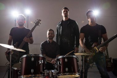 Rock band takım ayakta gitar ve davul seti ile sahnede portresi