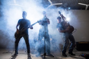 Rock and roll grubu sahne sahne ışıkları ve duman ile yaşamak