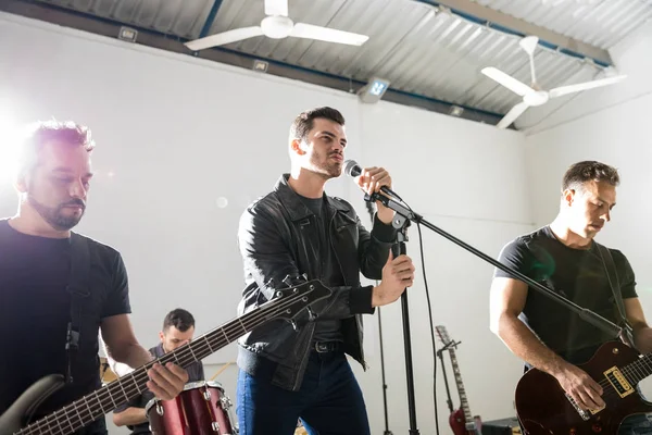 Jovem Cantando Microfone Com Seus Membros Banda Redor Palco — Fotografia de Stock