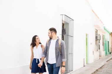 Gülümseyen çift birbirleriyle konuşurken kaldırımda yürüyen