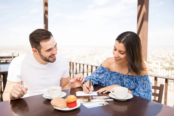 年轻的拉丁情侣写的记忆背后的图片的硬拷贝在阳台咖啡馆的早餐 — 图库照片