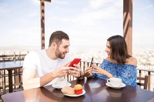 Healthy Smiling Couple Using Smartphones Talking While Eating Breakfast — Stock Photo, Image