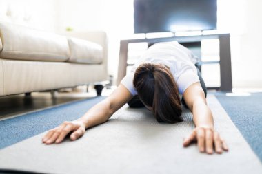 Çocuk oturma odasında egzersiz mat poz yoga yaparken esnek genç kadın