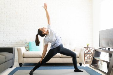 kadın fitness mat evde oturma odasında yoga yaparken uygun