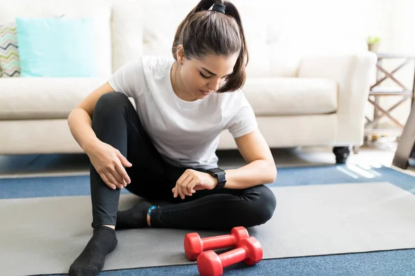 Jeune Femme Assise Sur Tapis Yoga Dans Salon Réglage Smartwatch — Photo