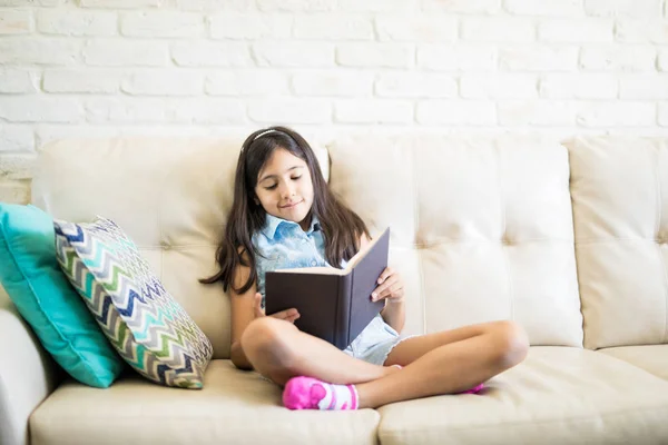Menina Casual Livro Leitura Roupas Enquanto Sentado Sofá Bege Casa — Fotografia de Stock