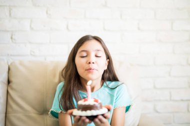 pasta tutarak ve kapalı gözlerle dilek ve evde kanepede otururken darbe mum için hazır hale kız
