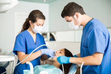 Klinikte diş ekipman ile genç hastayı tedavi tıbbi iş arkadaşları