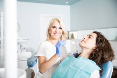 Güzel kadın dişçi diş kliniği hastada ile onun iş zevk portresi