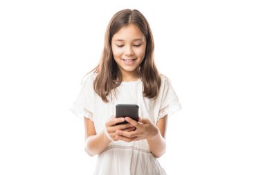 Sevimli küçük gülümseyen kız beyaz arka plan üzerinde izole modern smartphone kullanarak 