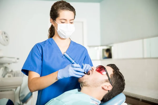 Kadın Dişçi Diş Kliniğinde Tedavi Gören Orta Yetişkin Adam — Stok fotoğraf