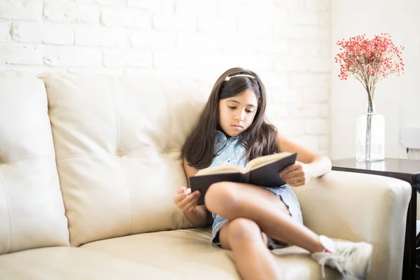 Chica Ropa Casual Libro Lectura Mientras Está Sentado Sofá Beige — Foto de Stock
