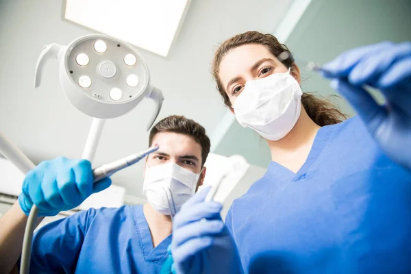 Erkek Kadın Diş Hekimleri Diş Kliniğinde Çalışırken Maskeli Düşük Açılı — Stok fotoğraf