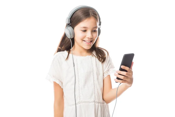 在白色背景下手持手机收听音乐的快乐小女生肖像 — 图库照片