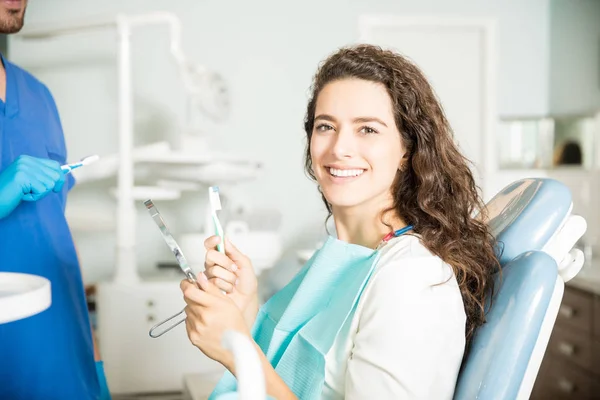 Портрет Усміхненої Молодої Жінки Тримає Зубну Щітку Дзеркало Стоматолога Клініці — стокове фото