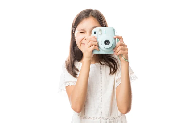 微笑的年轻女孩拿着相片照相机并且拍照在白色背景被隔绝了 — 图库照片