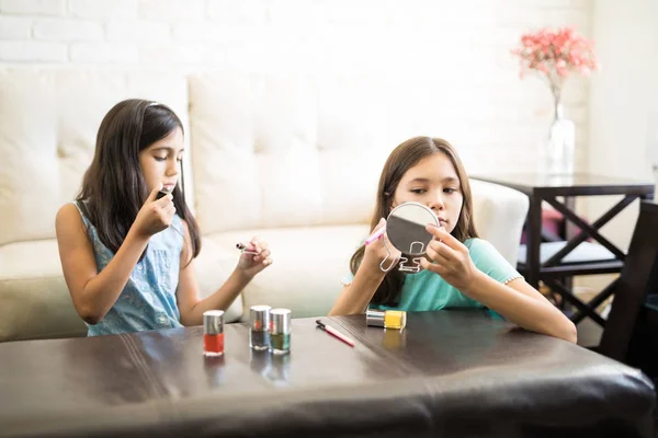 Siskot Soveltavat Meikkiä Leikkiessään Kosmeettisia Lisävarusteita Olohuoneessa Kotona — kuvapankkivalokuva