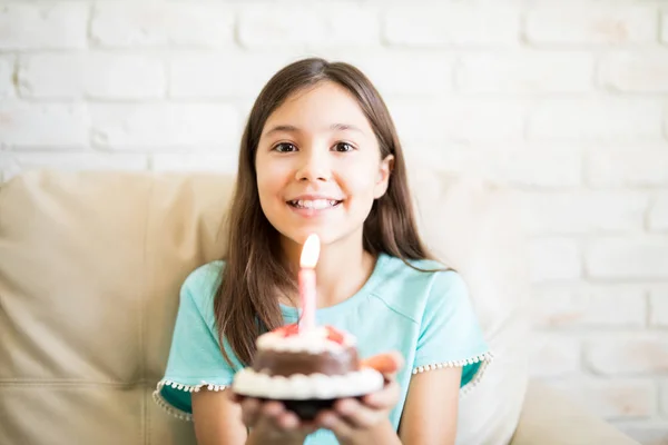 Girl Gazdaság Csokoládé Muffin Egy Égő Gyertyát Kanapén Otthon Ülve — Stock Fotó