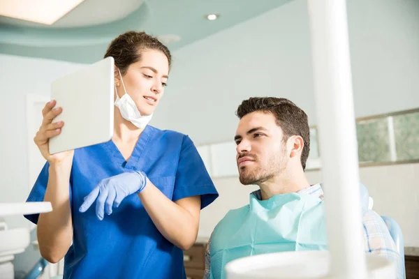 Dentista Mujer Discutiendo Mientras Muestra Tableta Digital Paciente Masculino Clínica — Foto de Stock