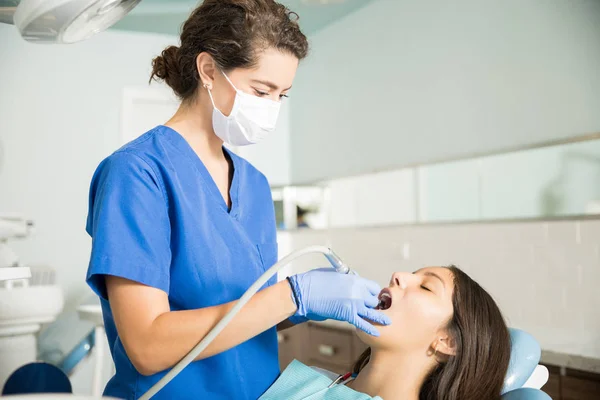 Dentista Feminina Usando Máscara Cirúrgica Enquanto Examina Adolescente Com Equipamentos — Fotografia de Stock