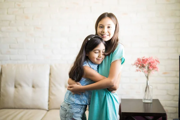 Sweet younger sister hugging elder sister at home — Stock Image Sweet Younger Sister Hugging Elder Sister Home Stock Image