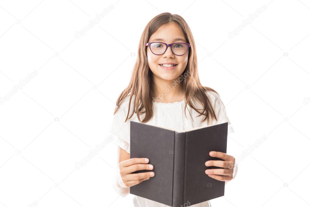 Portrait of little adorable girl wearing white shirt and spectacles holding open book against white background 