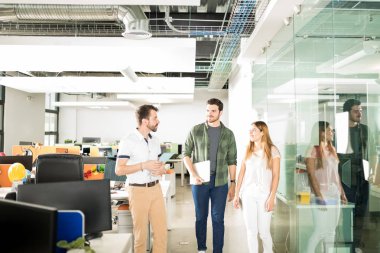 Üç latin iş adamları birlikte ofiste ayakta ve yeni proje tartışıyor 