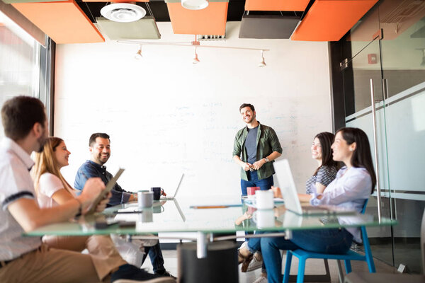 young good looking man giving business presentation to colleagues in meeting room