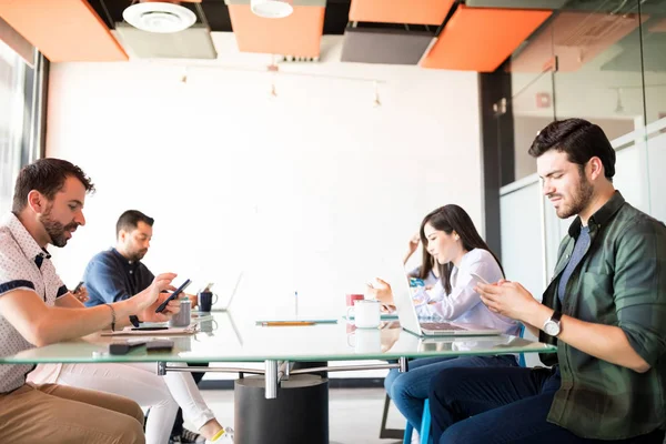 Grupp Affärsmän Sitter Runt Konferensbord Och Använder Sina Mobiltelefoner Och — Stockfoto