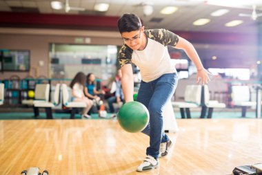 Kendine güvenen genç çocuk onun salıncak bir bowling salonu, pratik tam uzunlukta